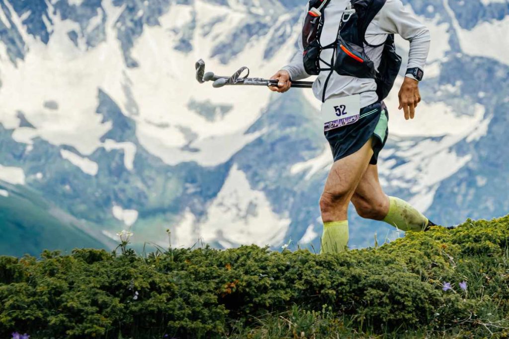 Corredor en montaña con bastones
