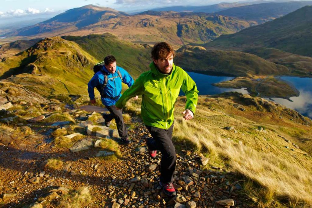 Hombres corriendo en montaña verde