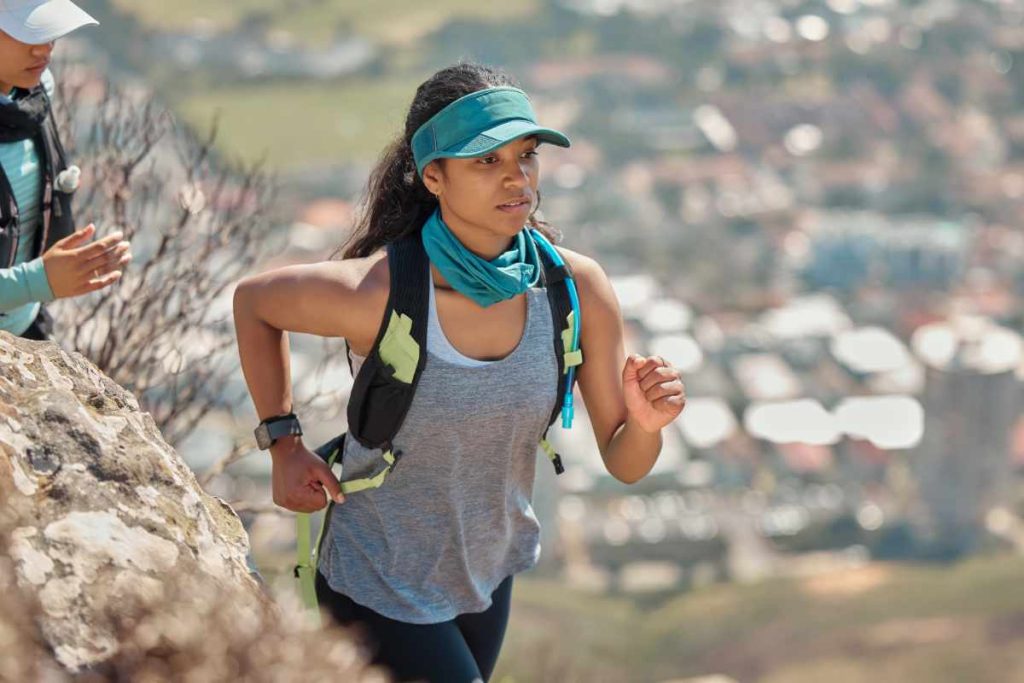 Mujer corriendo en sendero montañoso.
