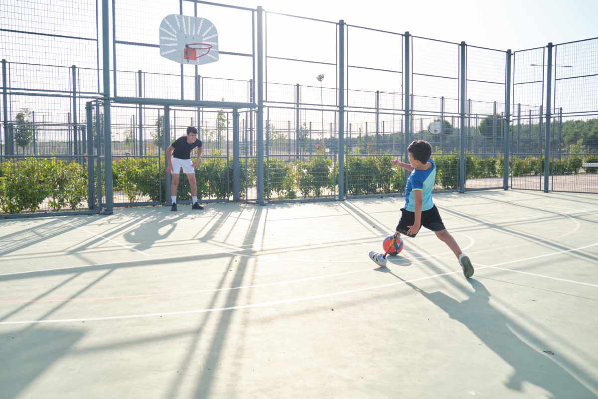 Niño jugando fútbol en cancha