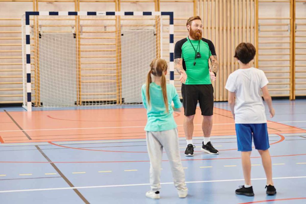 Entrenador hablando con niños en gimnasio