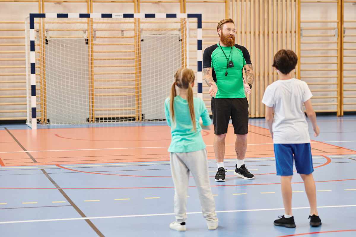 Entrenador hablando con niños en gimnasio