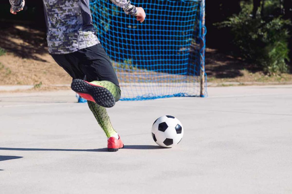 Jugador patea balón en cancha
